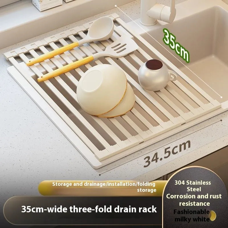 A milky white foldable stainless steel kitchen draining rack collapsed flat beside a kitchen sink.