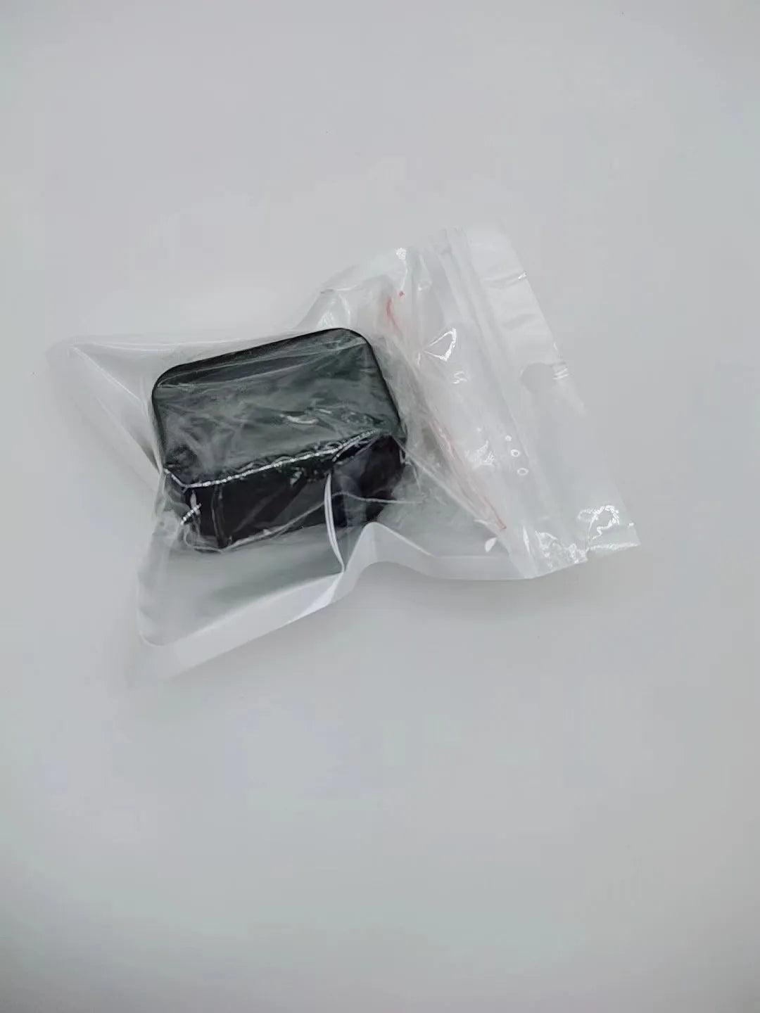 Black plastic seat belt lock clamp device shown on a car seat buckle.