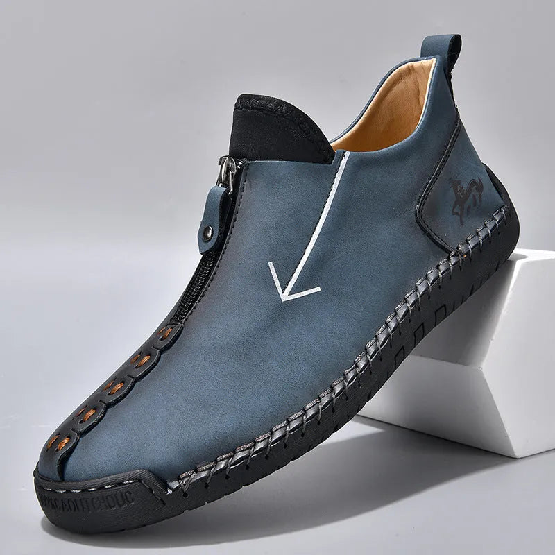 Men's black leather boots with front zipper, hand-stitched detailing, and rubber sole on a neutral background