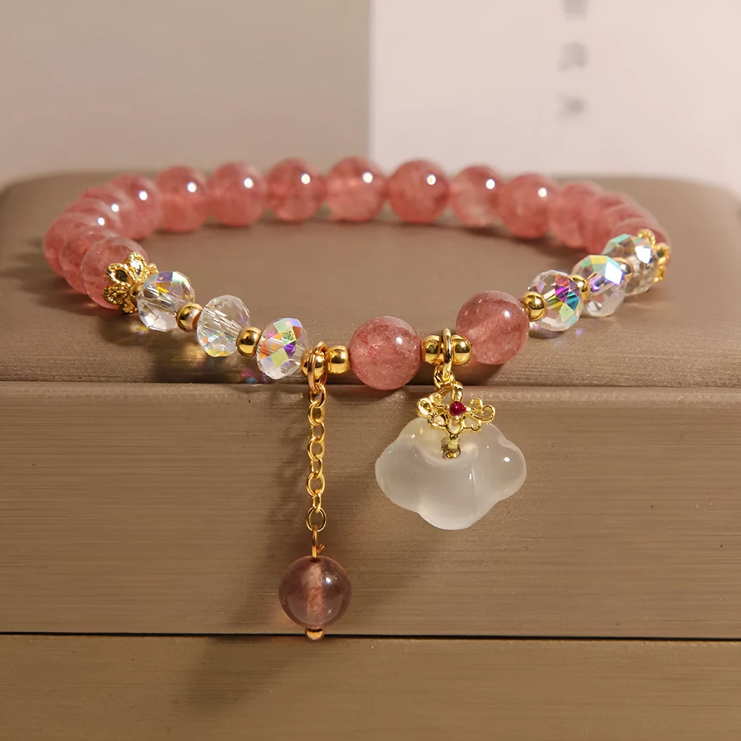 Women's adjustable crystal bracelet with strawberry quartz, white agate beads, and auspicious cloud charms