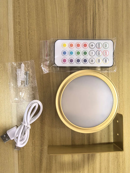 Black magnetic LED painting lamp with remote control on a white wall.