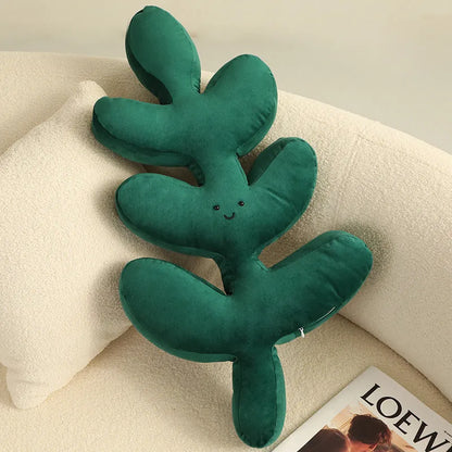 Green embroidered plant cushion with monstera leaf pattern on plush fabric