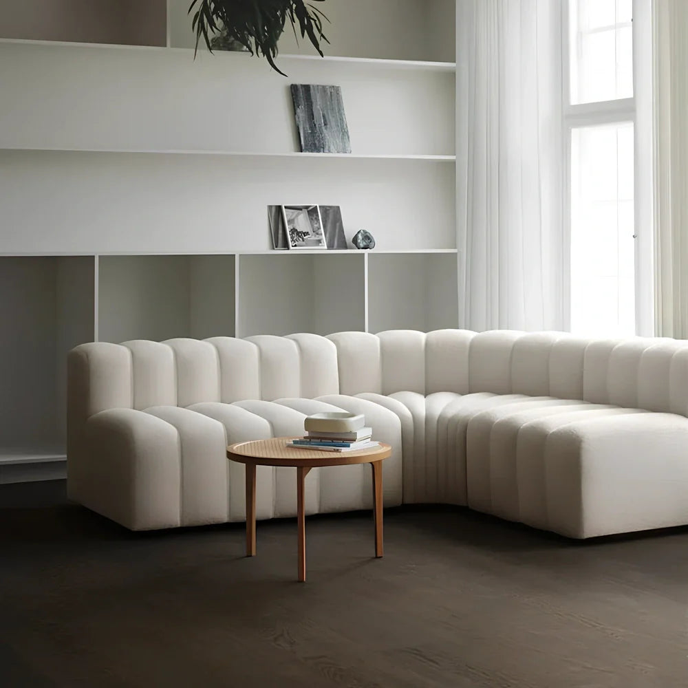 Off-white curved modular sofa with fleece fabric in corner configuration showing multiple connected pieces