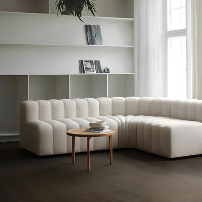 Off-white curved modular sofa with fleece fabric in corner configuration showing multiple connected pieces
