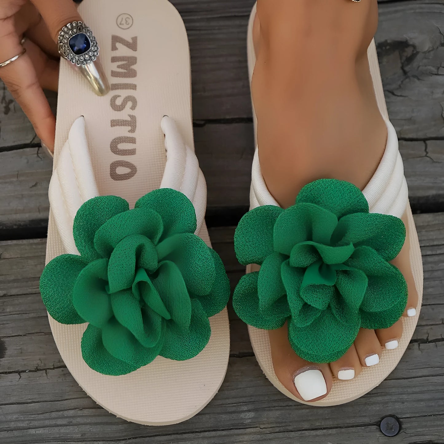Women's plus size green PU flip flop slippers with flower pattern on a white background.