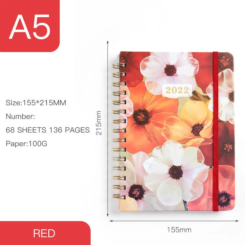 A5 spiral coil notebook open showing annual calendar pages and spiral binding