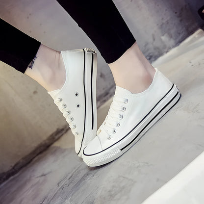 Women's low-top canvas shoes in solid colours on a plain background, showing rubber sole and classic casual style.