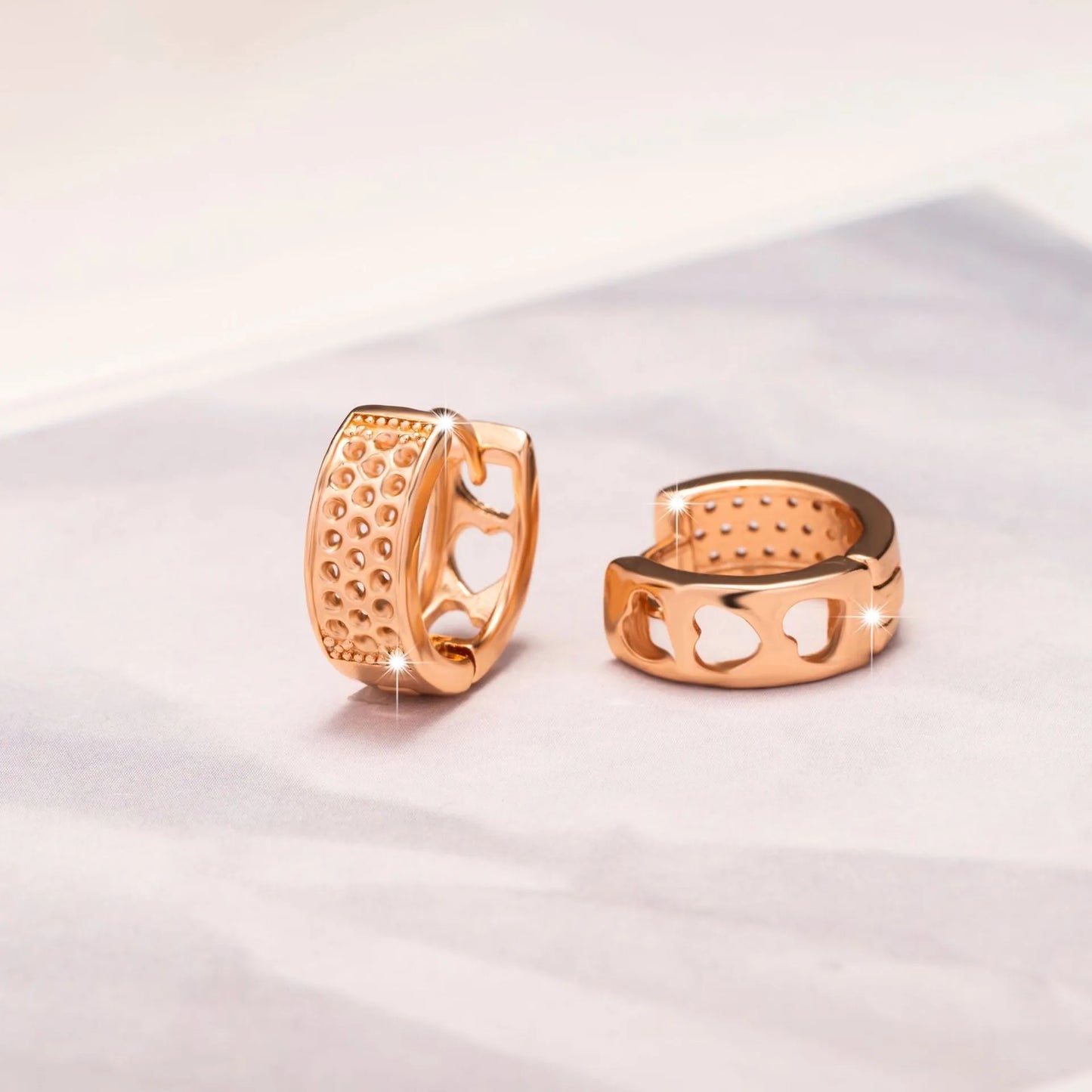 Rose gold electroplated earrings with 2.5cm circular design and three heart-shaped cut-outs