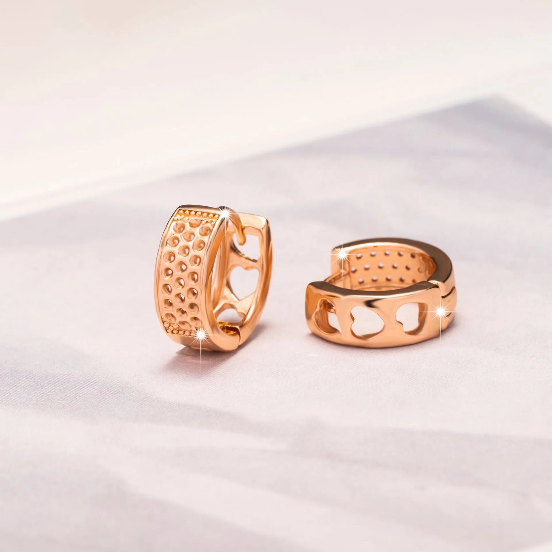 Rose gold electroplated earrings with 2.5cm circular design and three heart-shaped cut-outs