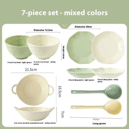 Boxed set of seven solid-colour ceramic plates and bowls on a table.