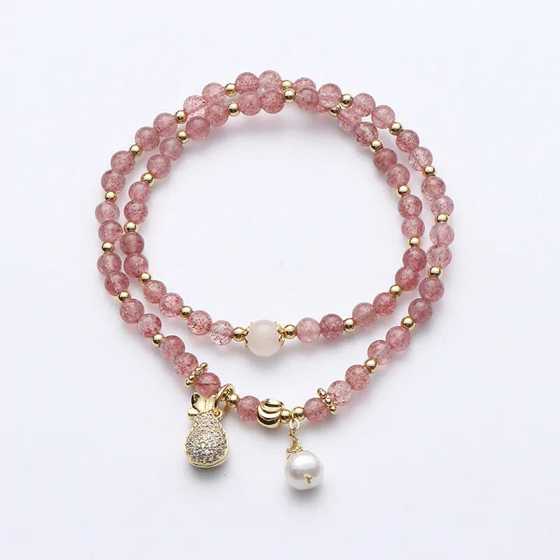 Women's geometric strawberry quartz crystal bracelet with a silver wallet money charm.