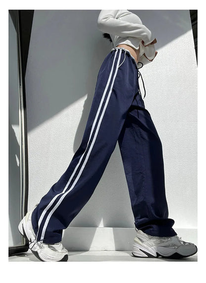 Women's loose straight leg trousers with ribbon parallel bars contrast colour detail on low waist, in thin fabric.