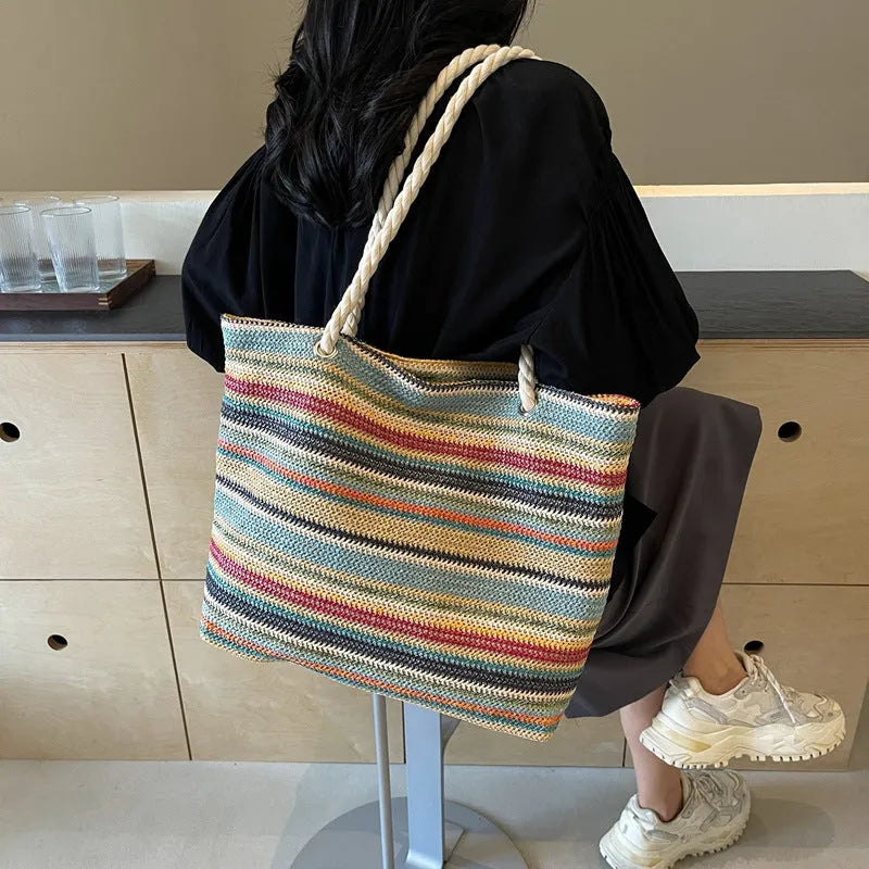 Blue straw-woven nylon shoulder bag with a single strap and large compartment.
