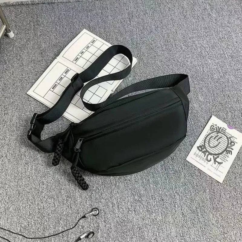 Men's polyester crossbody bag in black colour showing shoulder strap and front compartment