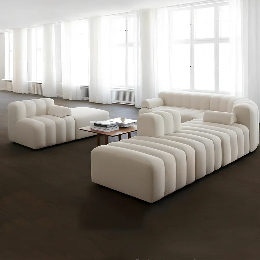 Off-white curved modular sofa with fleece fabric in corner configuration showing multiple connected pieces