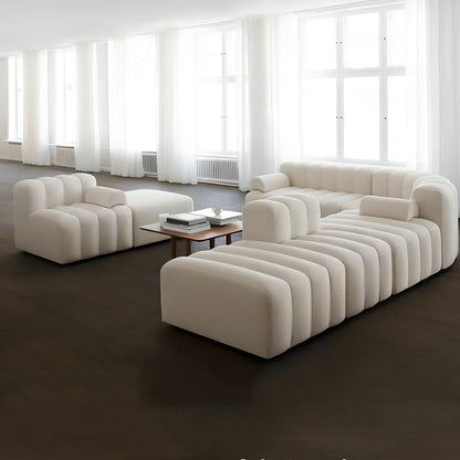 Off-white curved modular sofa with fleece fabric in corner configuration showing multiple connected pieces