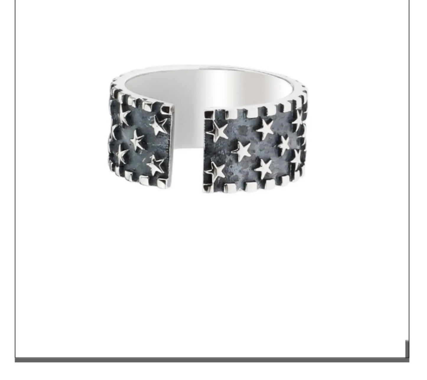 Close-up of a polished sterling silver ring with a raised five-pointed star pattern on an adjustable band.
