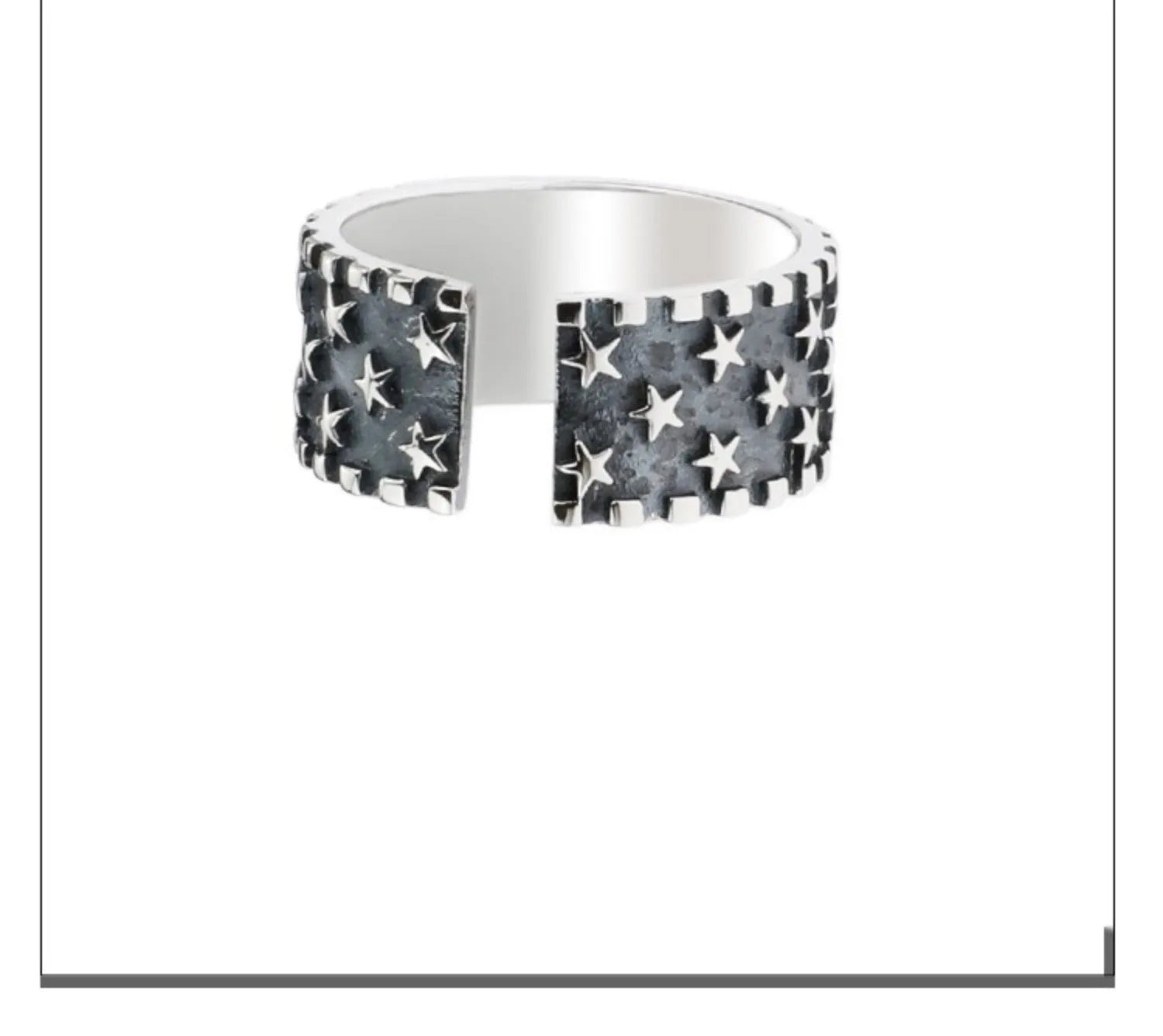 Close-up of a polished sterling silver ring with a raised five-pointed star pattern on an adjustable band.