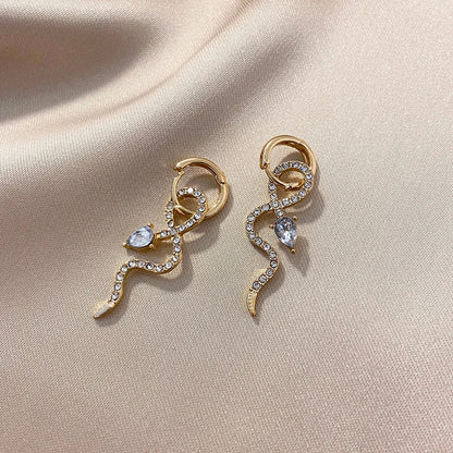 Pair of golden snake-inspired dangle earrings with a captivating and elegant design