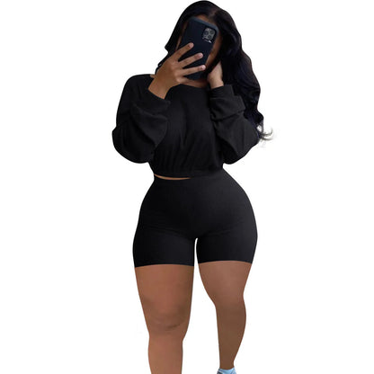 Women's long sleeve off-the-shoulder top and shorts two-piece set in a solid colour.