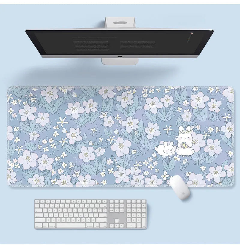 Large floral pattern mouse pad on a wooden desk with a computer mouse.