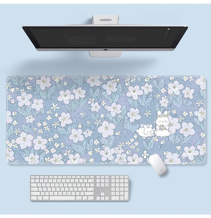 Large floral pattern mouse pad on a wooden desk with a computer mouse.