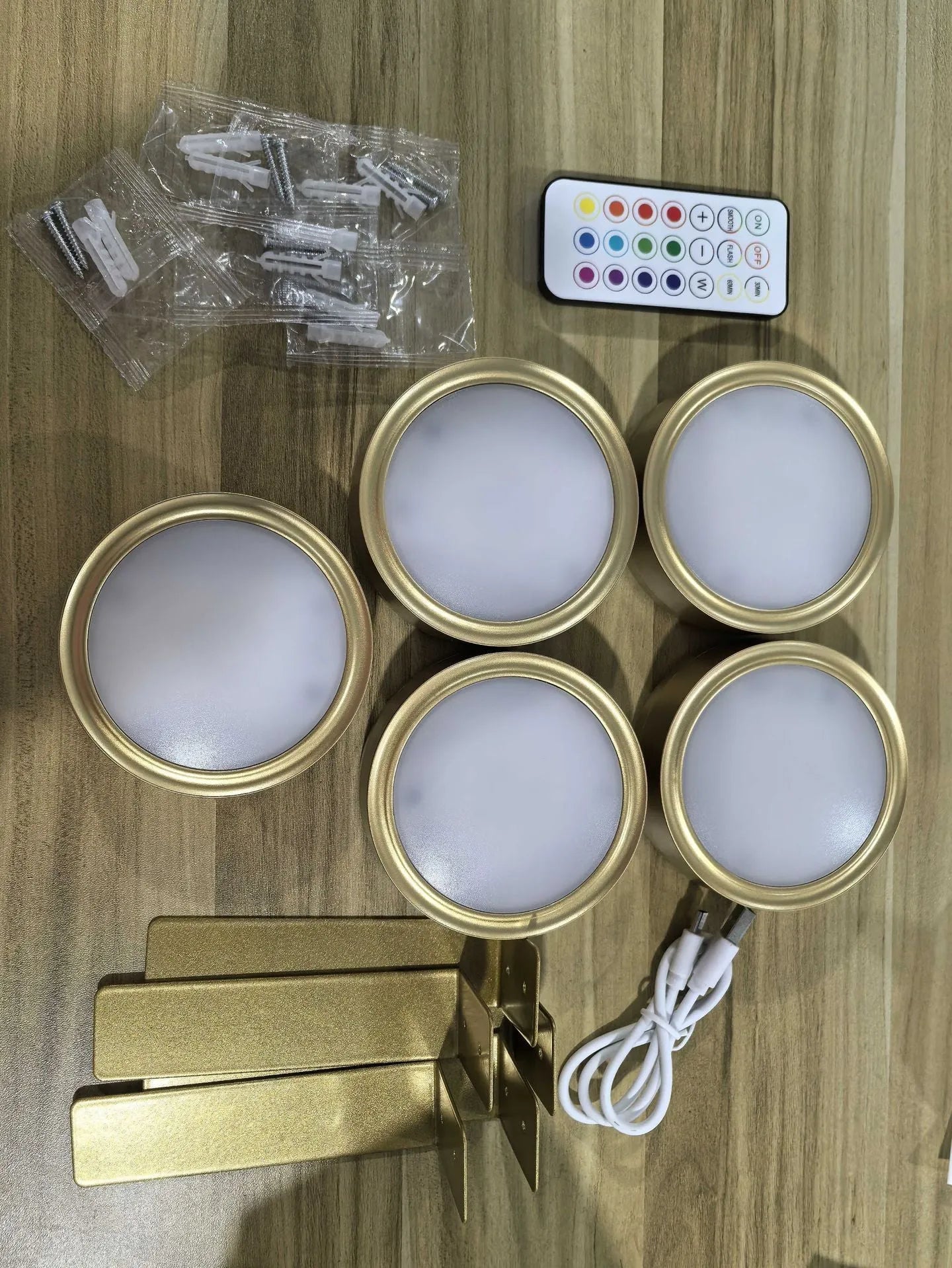 Black magnetic LED painting lamp with remote control on a white wall.