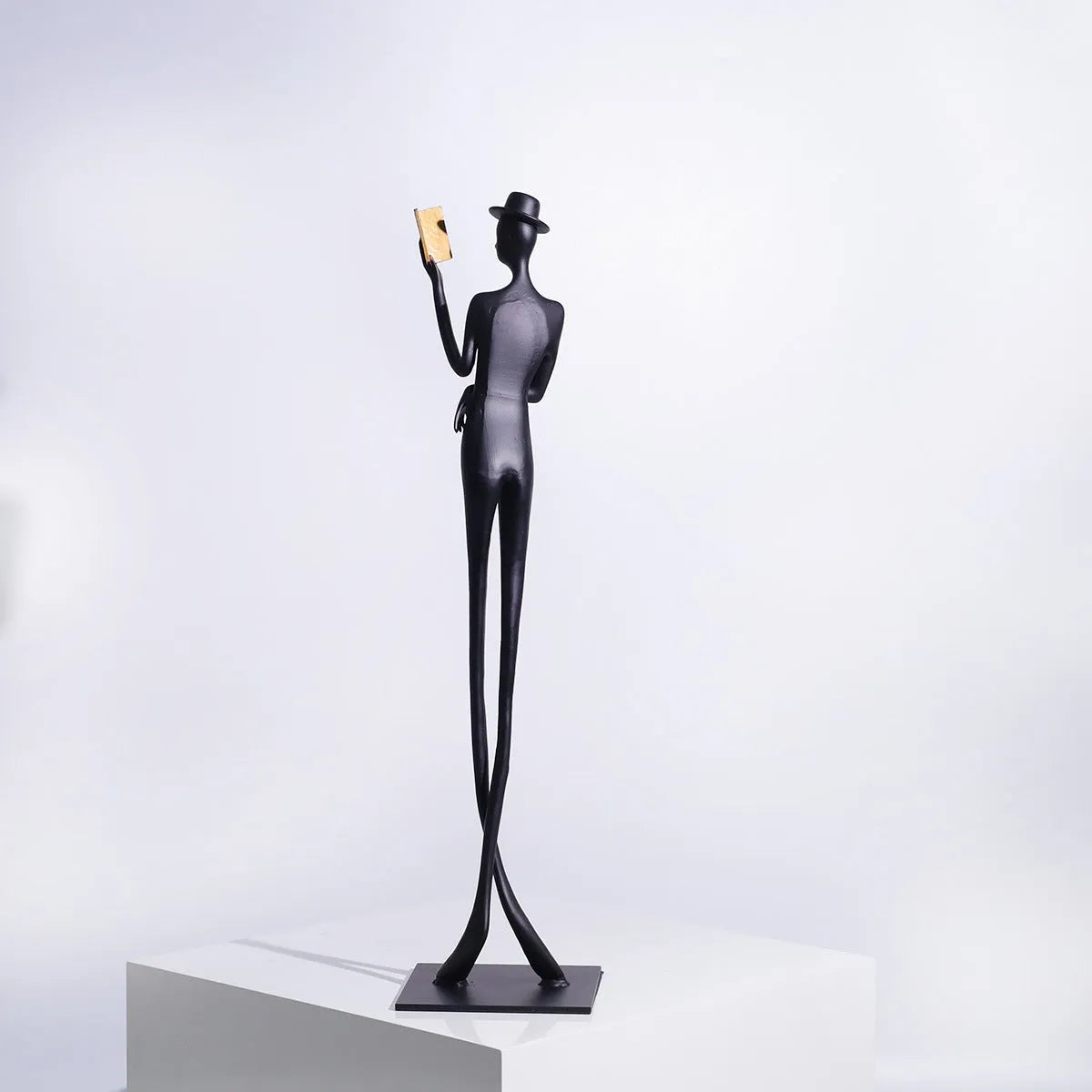 Black cast aluminium desktop sculpture of reading woman measuring 12x12x51cm with modern simplicity design