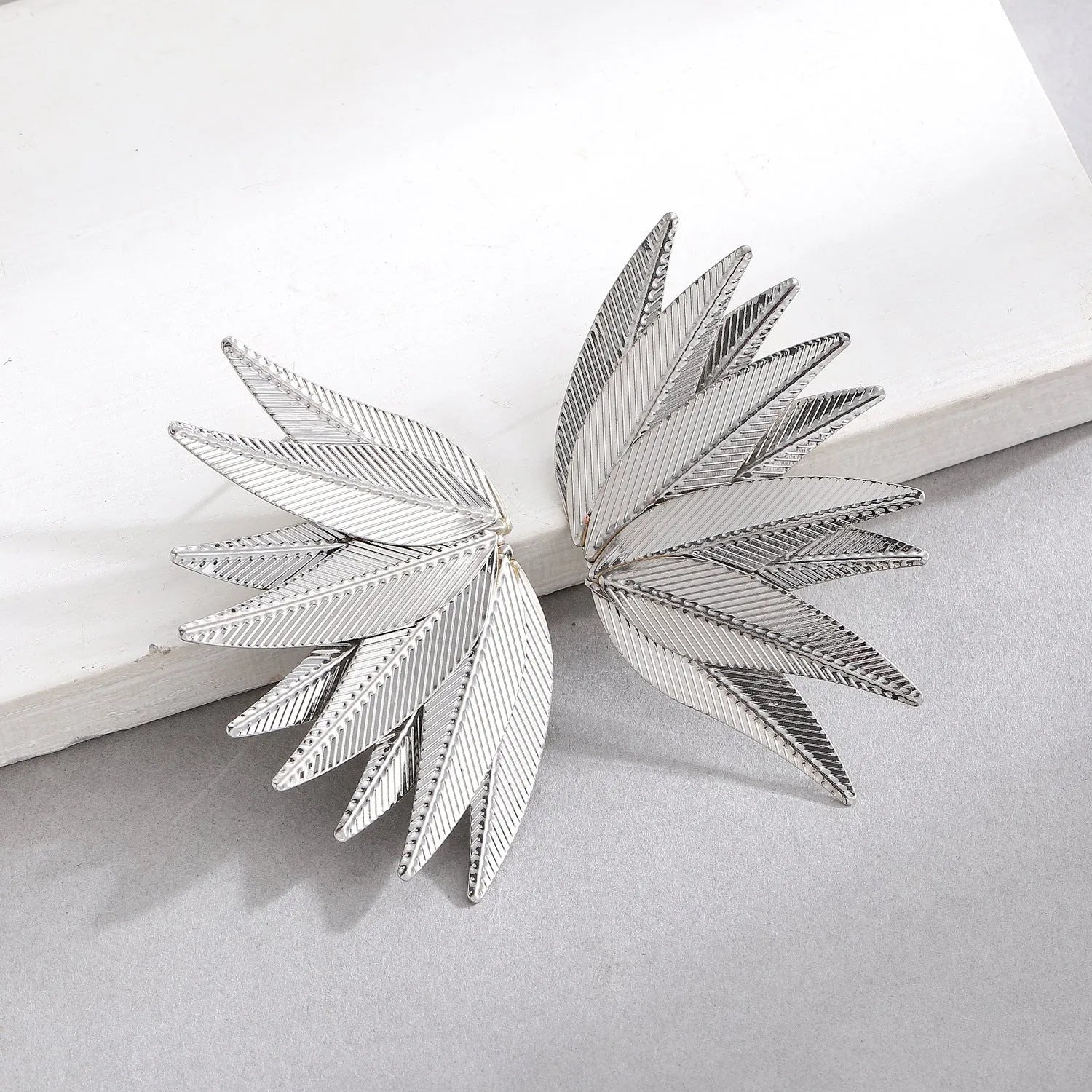 Gold and white alloy leaf-shaped patch earrings with dangle design