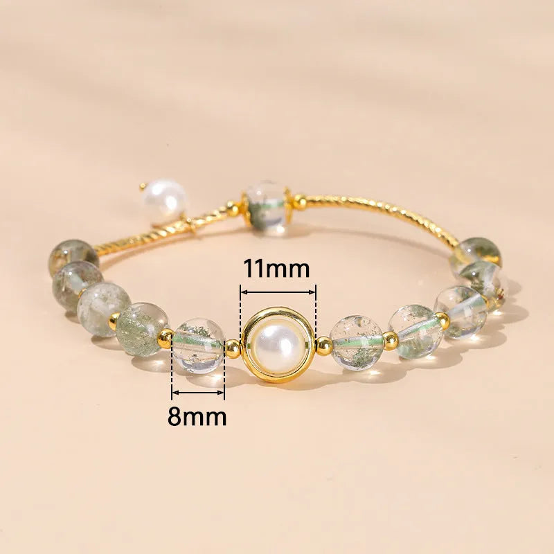 Close-up of a manually crafted crystal agate bracelet with shaped animal and fruit beads.