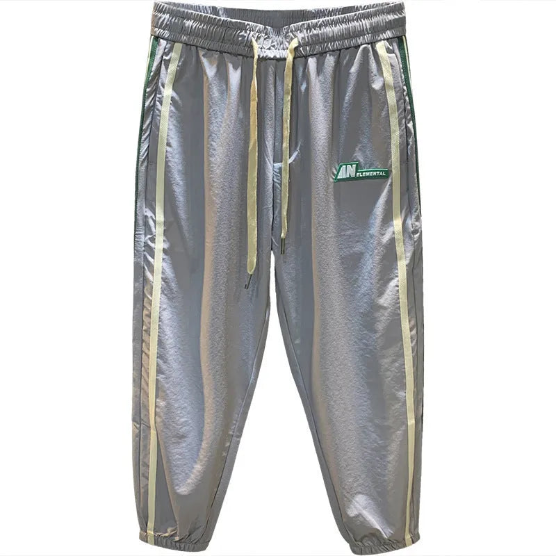 Man wearing black cotton harem-style sport trousers with an elasticated mid-waist.