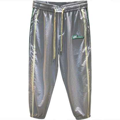 Man wearing black cotton harem-style sport trousers with an elasticated mid-waist.