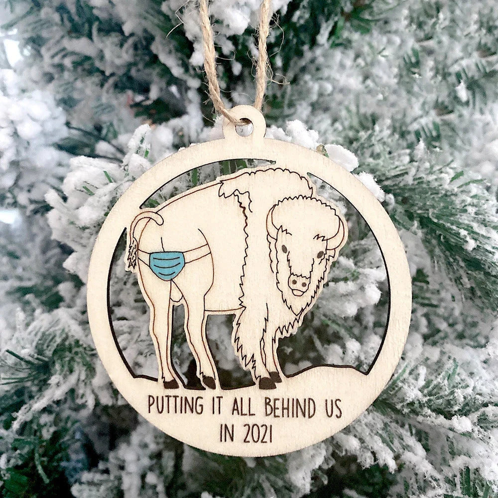 Wooden hollowed-out Christmas ornament with intricate snowman and deer laser-cut design