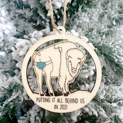 Wooden hollowed-out Christmas ornament with intricate snowman and deer laser-cut design