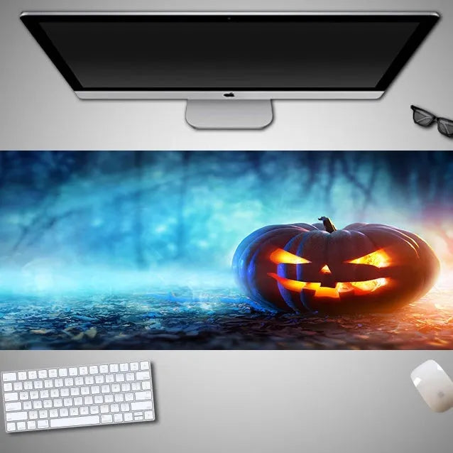 Oversized black Halloween-themed mouse pad with graphic design on a wooden desk, showing non-slip rubber base.