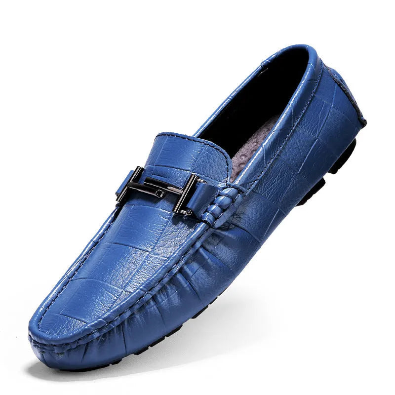 Men's brown leather casual shoes with a belt buckle on the upper, shown on a wooden surface.
