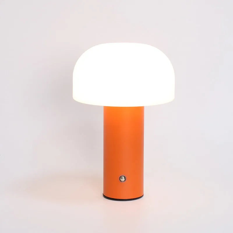 Compact white USB table lamp with integrated UK plug and a charging cable on a wooden desk.