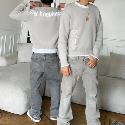 Grey loose-fitting jacquard knit coat with long sleeves on a hanger