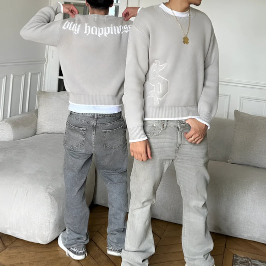 Grey loose-fitting jacquard knit coat with long sleeves on a hanger