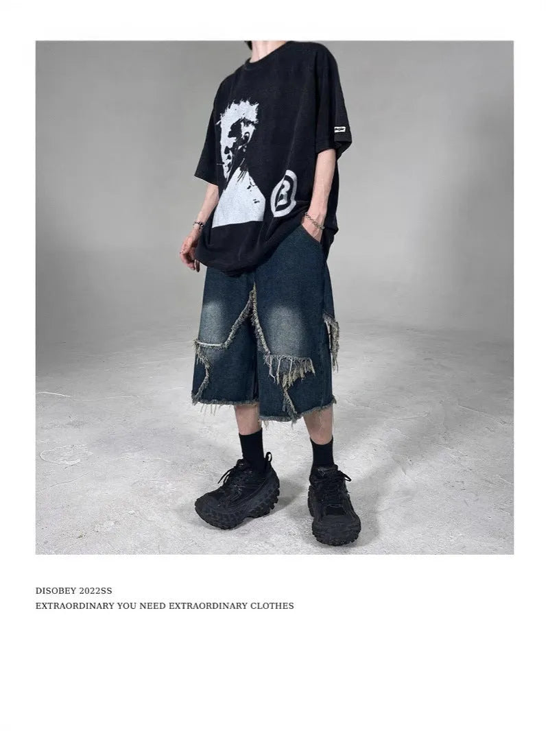 Blue men's loose-fit denim shorts with a frayed hem and a white five-pointed star patch on the leg.