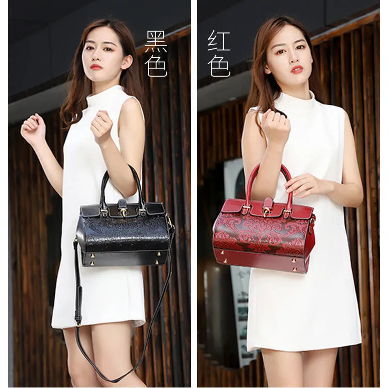 Vintage style women's genuine leather crossbody handbag featuring embossed oval sandwich pocket design with internal zipper changing bag, mobile phone bag, computer pocket and camera pocket organisation in red or black colour