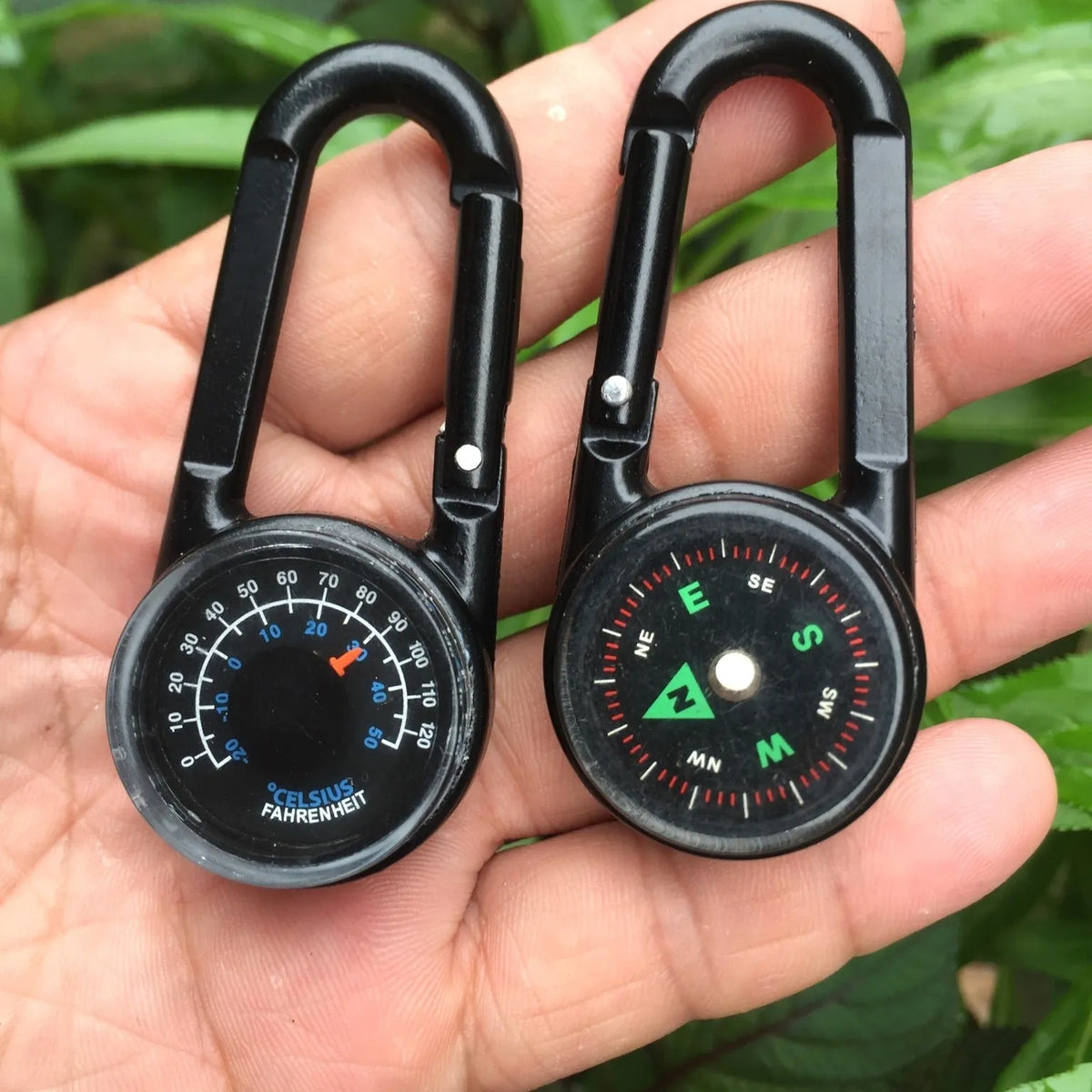 Black outdoor carabiner with a built-in circular compass and thermometer display on its side.