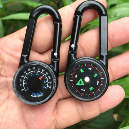 Black outdoor carabiner with a built-in circular compass and thermometer display on its side.