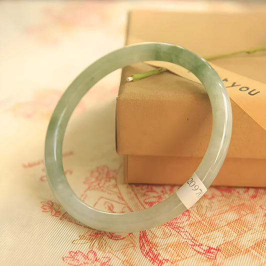 Green geometric jade waxy bracelet on a wrist, showing its 10mm thickness and Chinese style.
