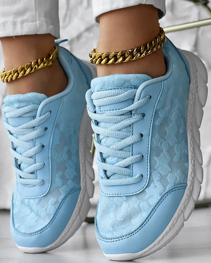 Women's canvas sports shoes in white with round toe and flat heel design on a light background