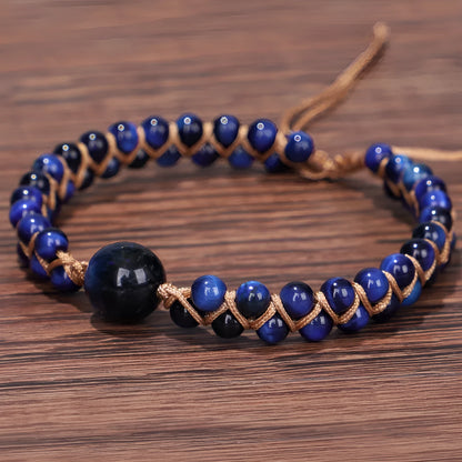 Handmade geometric pull bracelet woven from blue tigereye stone beads on a wrist.