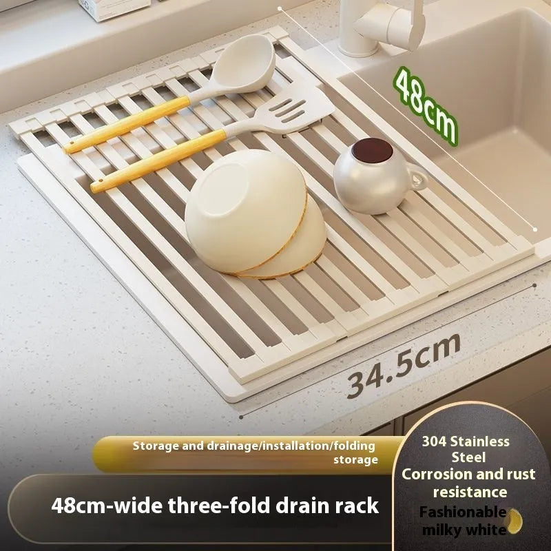 A milky white foldable stainless steel kitchen draining rack collapsed flat beside a kitchen sink.