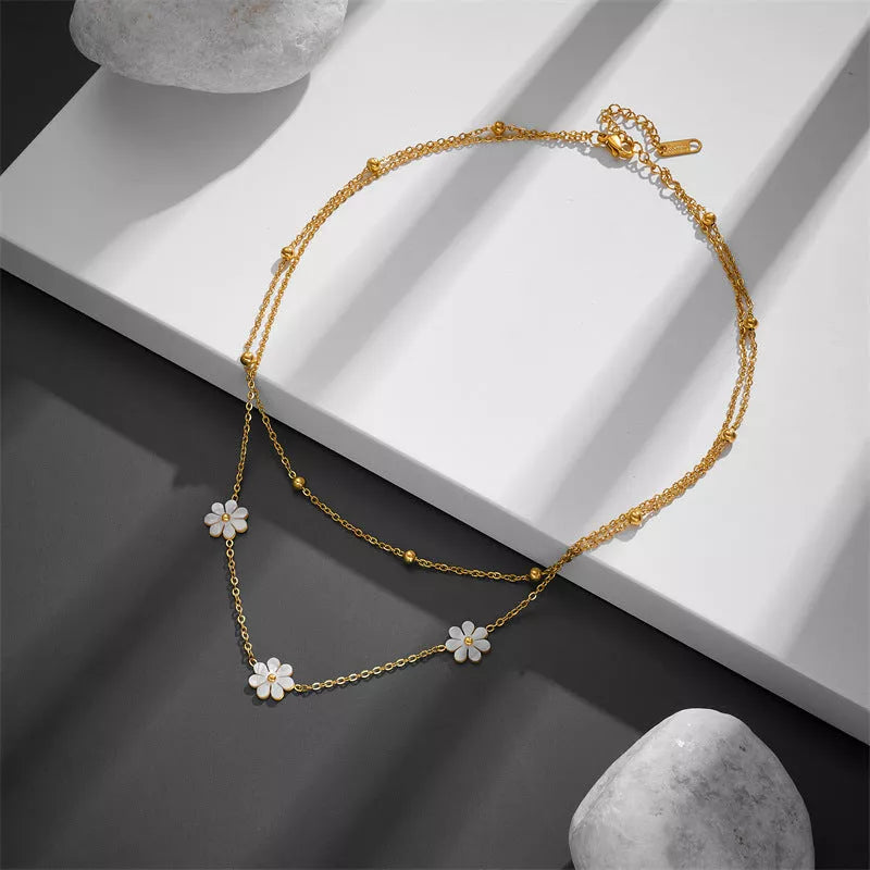 Stainless steel daisy flower jewelry set with necklace, bracelet, and earrings in electroplated gold finish