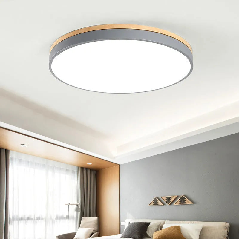 Round solid wood and acrylic LED ceiling lamp with dimming control in a modern living room setting.