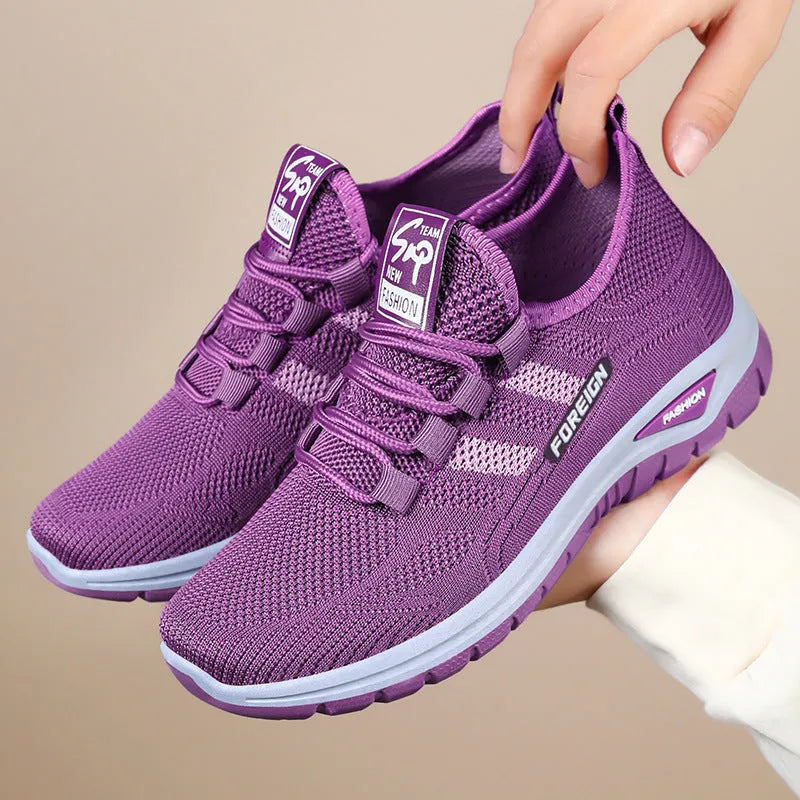 Low-top casual shoes with mesh upper and flat PVC sole in black, grey, purple, or red.